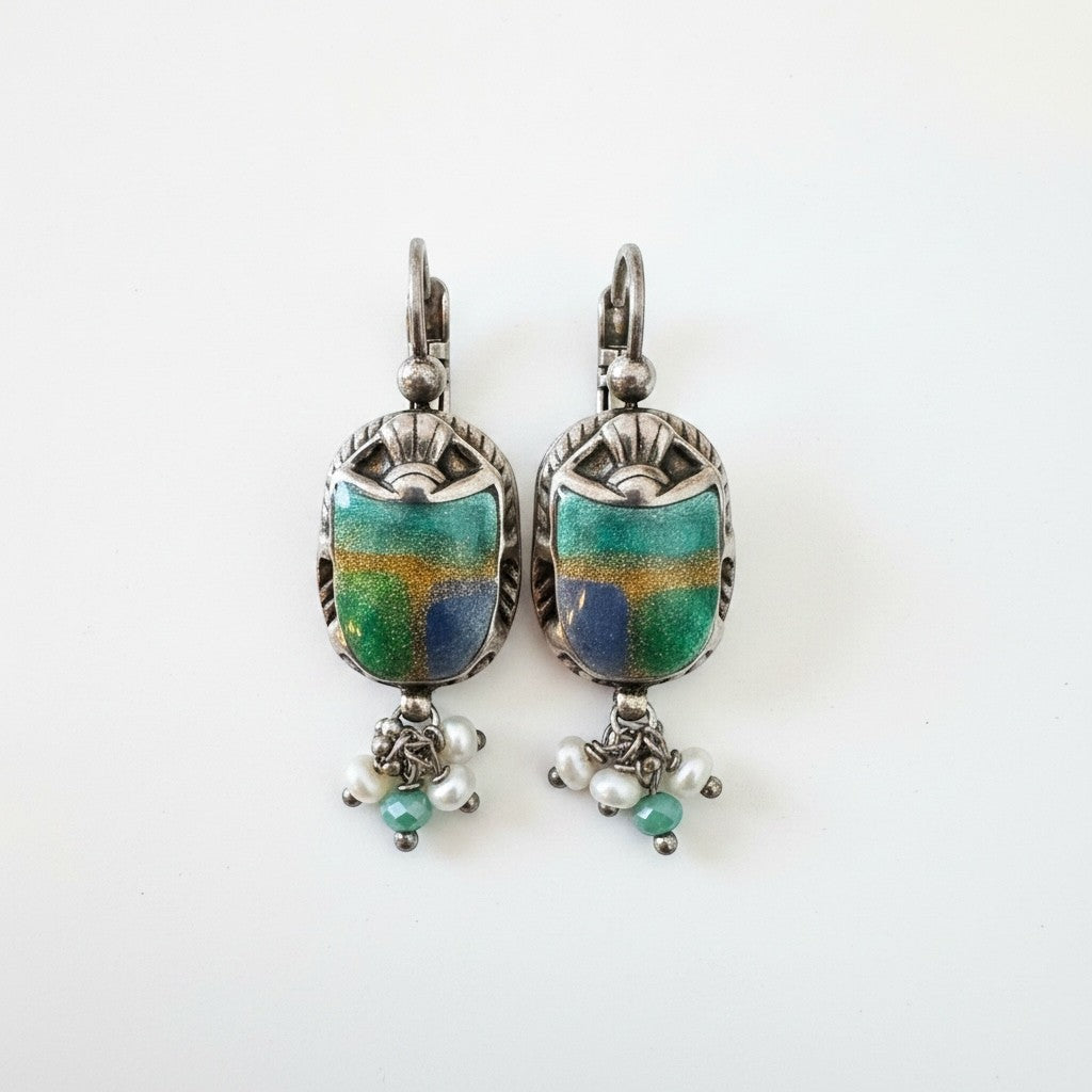 BY TOPAZE : Boucles d'oreilles pendantes Scaramouche dorées à l'or fin, ornées d'un scarabée bleu et vert émaillé, perles nacrées et pierres vertes.